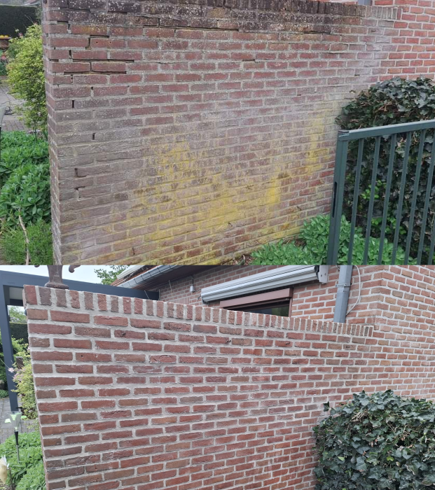 Bakstenen muur voor en na reiniging, met gele aanslag. JVH