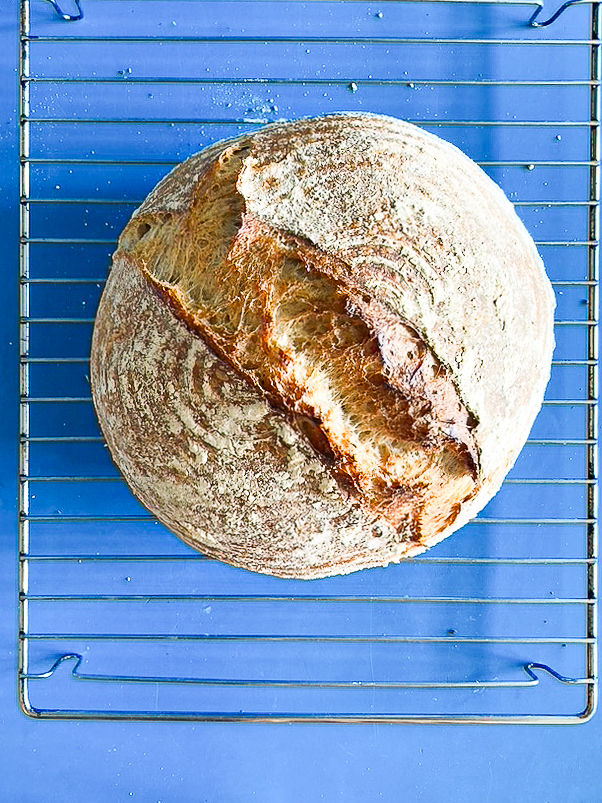 A loaf of sourdough bread on a blue table