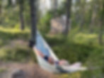 women in hammock in woods