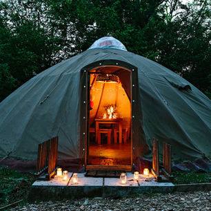 A yurt with lights inside making it look cosy