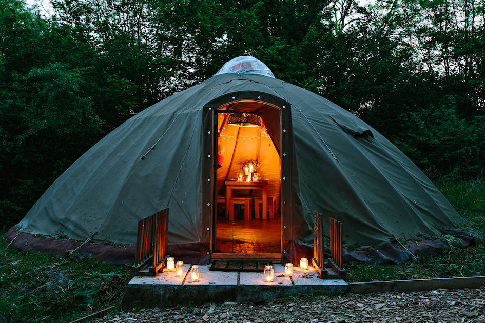 A yurt with lights inside making it look cosy