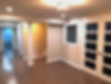 Finished basement renovation with modern lighting, hardwood floors, and white double doors