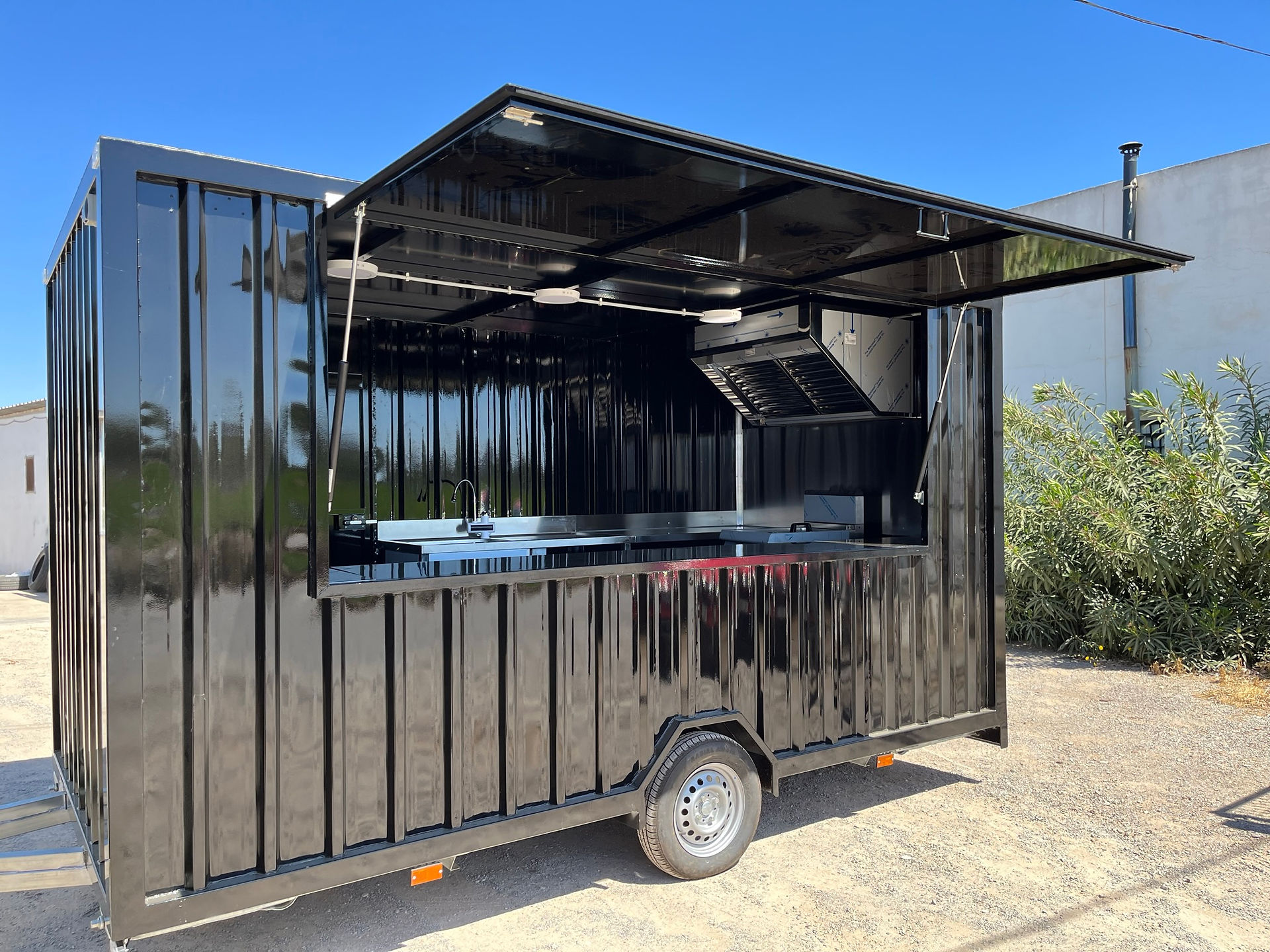 Food truck negro moderno con ventana abierta y equipo de cocina.
