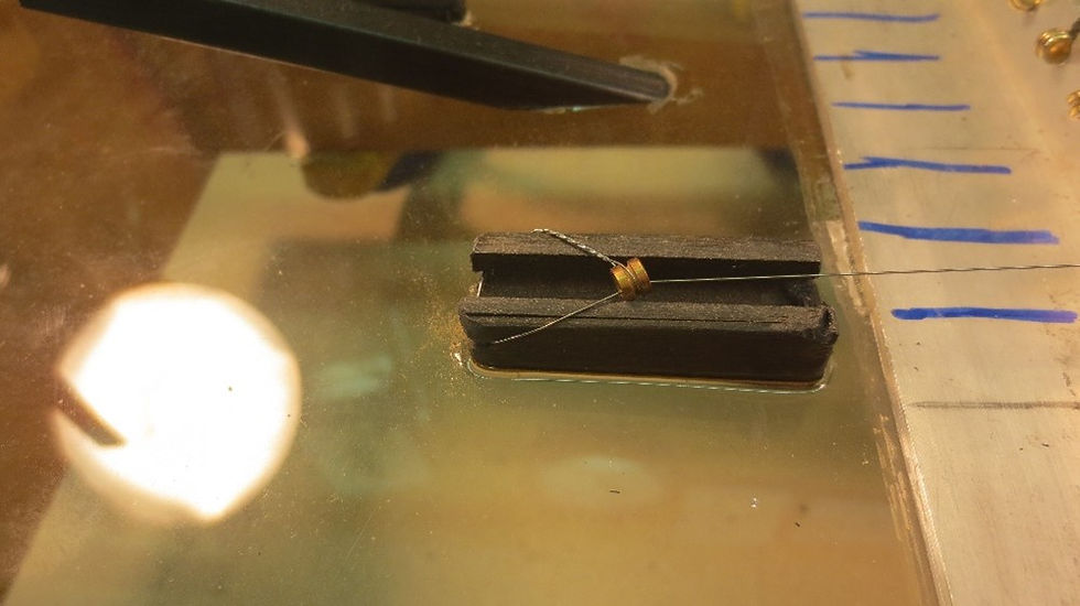 Simulated guitar string anchored by carbon fiber glued to glass