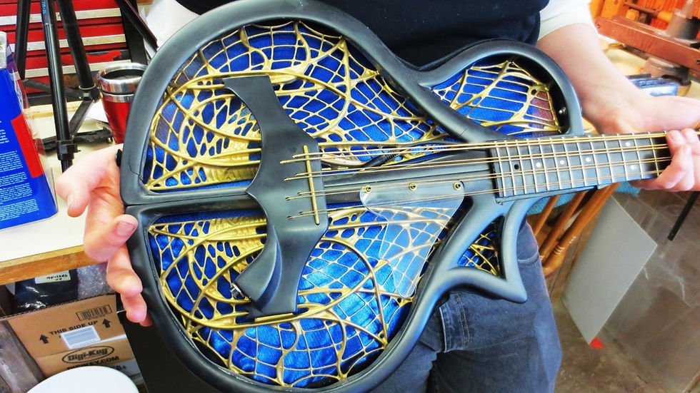 The black epoxy matrix molded around the carbon fiber perimeter strips has cracked on Harvey Reid's mandocello guitar under the much higher stress of the eight heavy strings