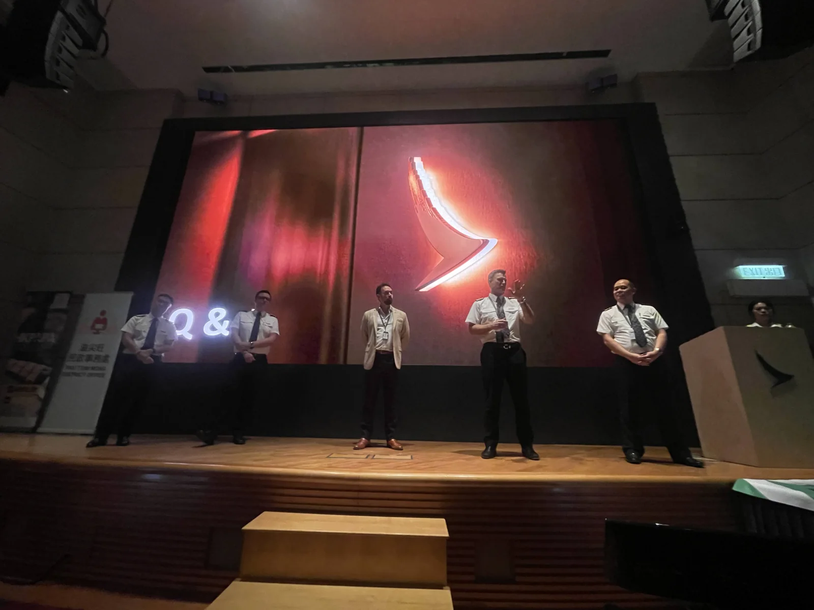 Four presenters on stage beneath a projected Q&A slide with the Cathay symbol.