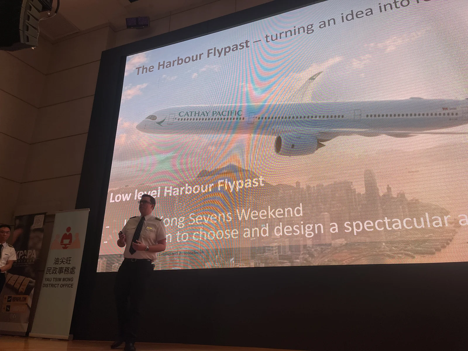 A speaker presents an Airbus aircraft image and a slide about turning the harbour fly-past idea into reality.