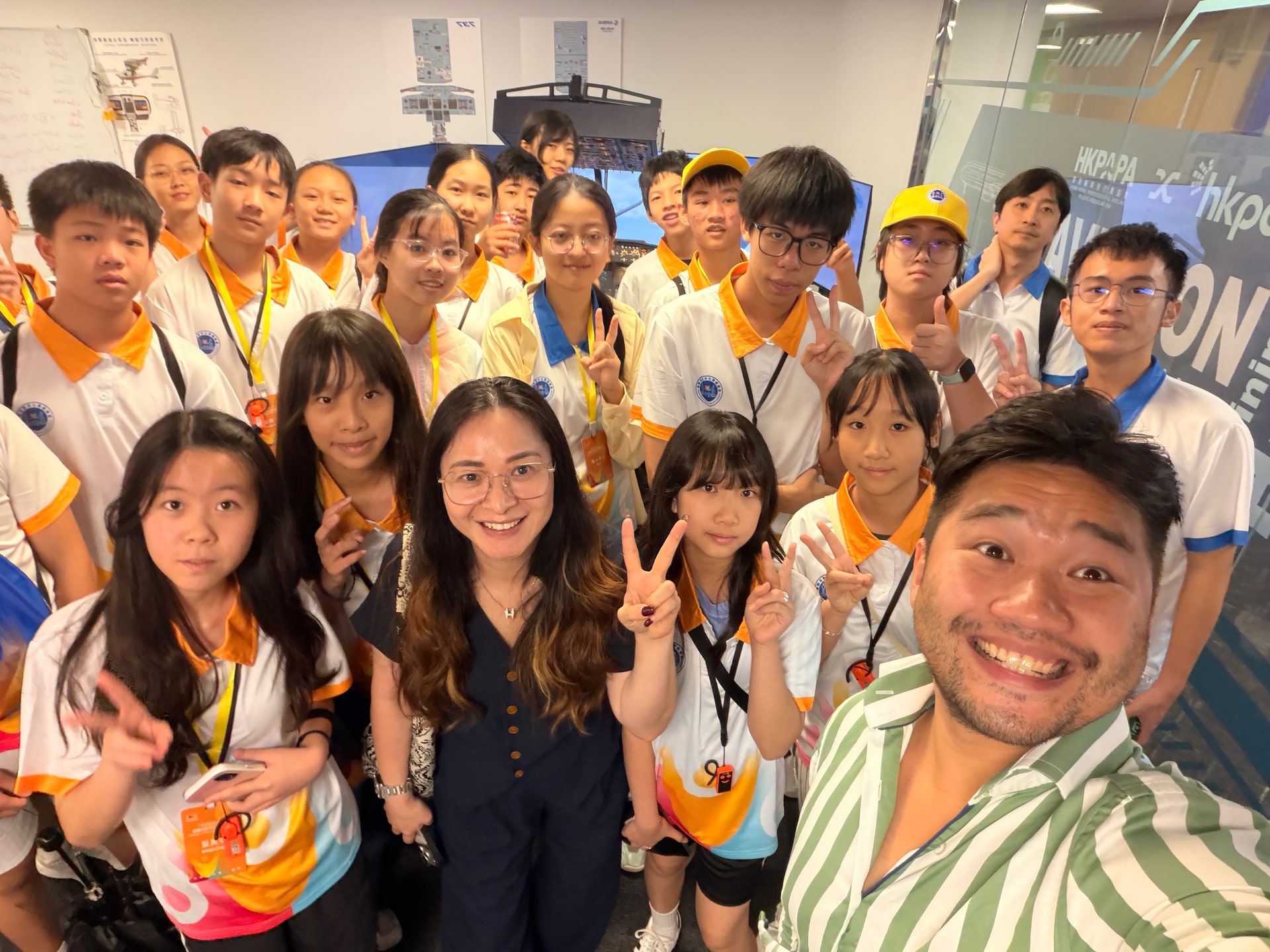 學生與志願機師主持人在HKPAPA的九龍塘訓練中心旁的飛行模擬器前聚集。