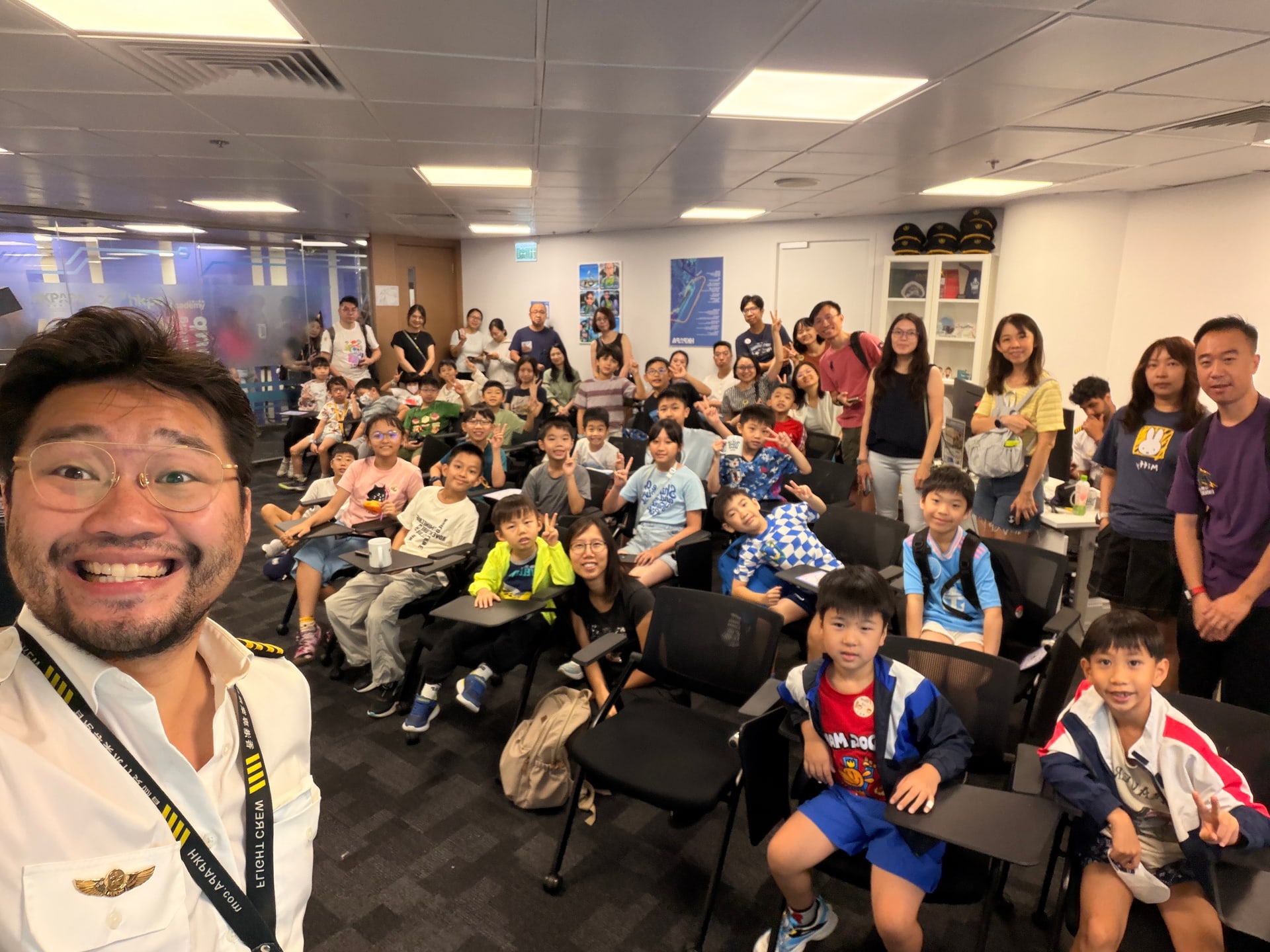 Children and parents celebrate completing an HKPAPA flight simulator workshop.