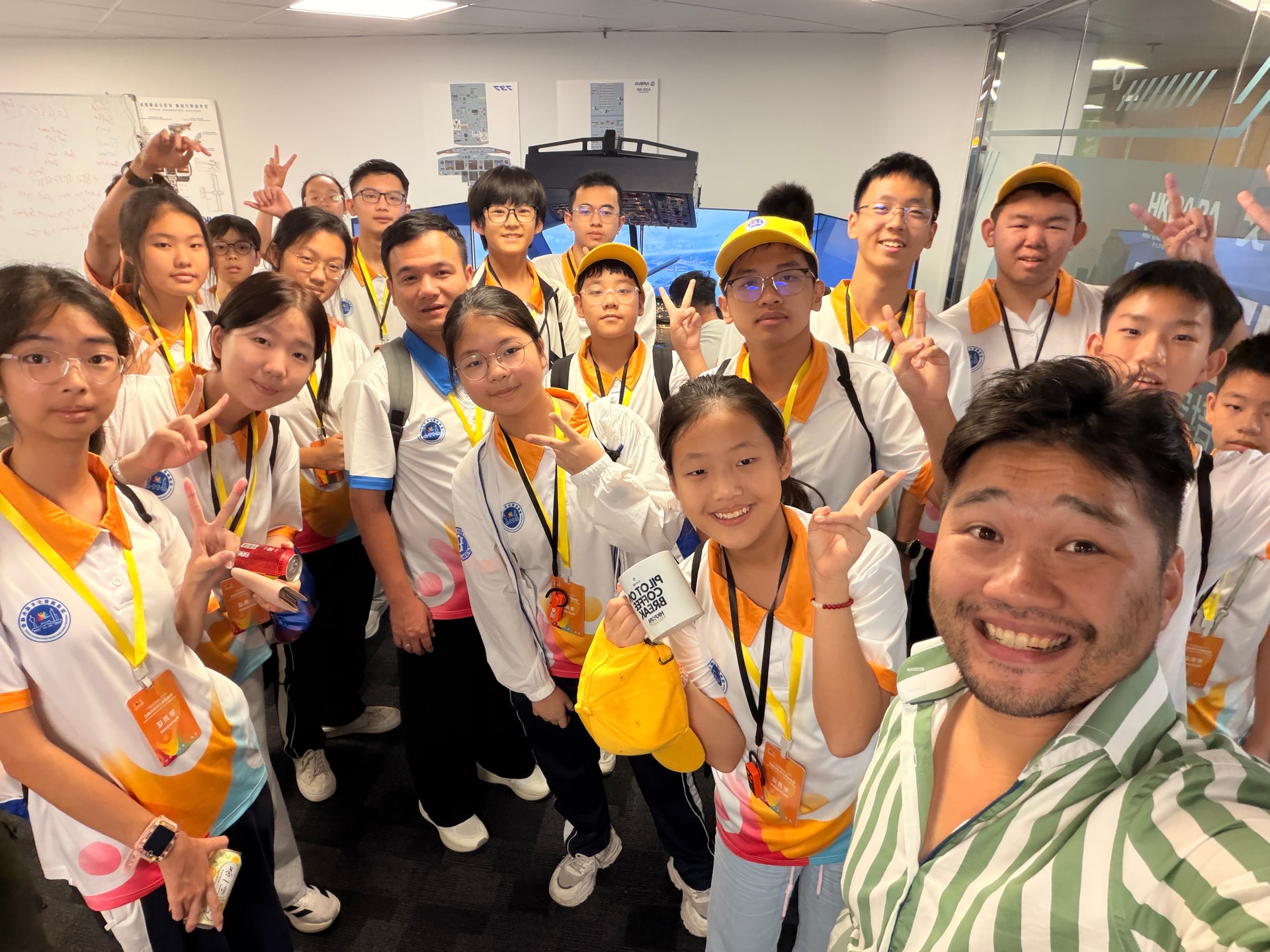 另一組到訪學生在香港HKPAPA飛行模擬器前與志願機師主持人會面。