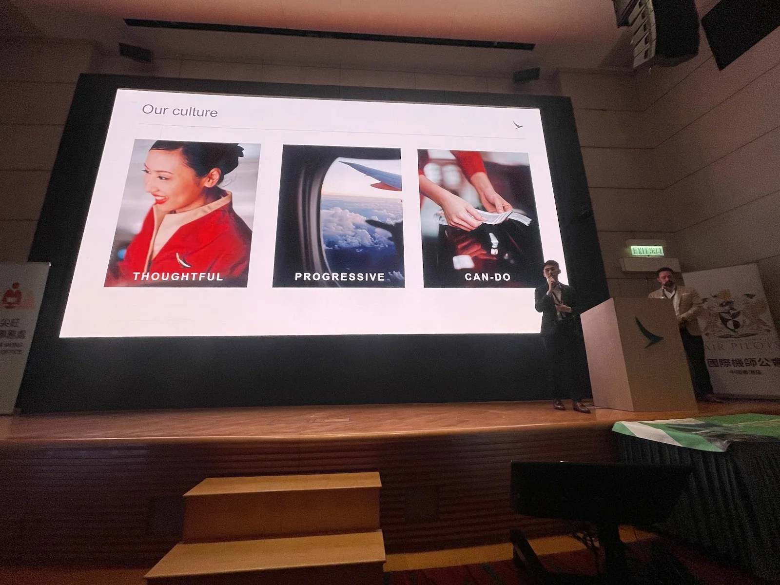 Two speakers beside a Cathay presentation slide headed Our culture, with Thoughtful, Progressive and Can-do values.