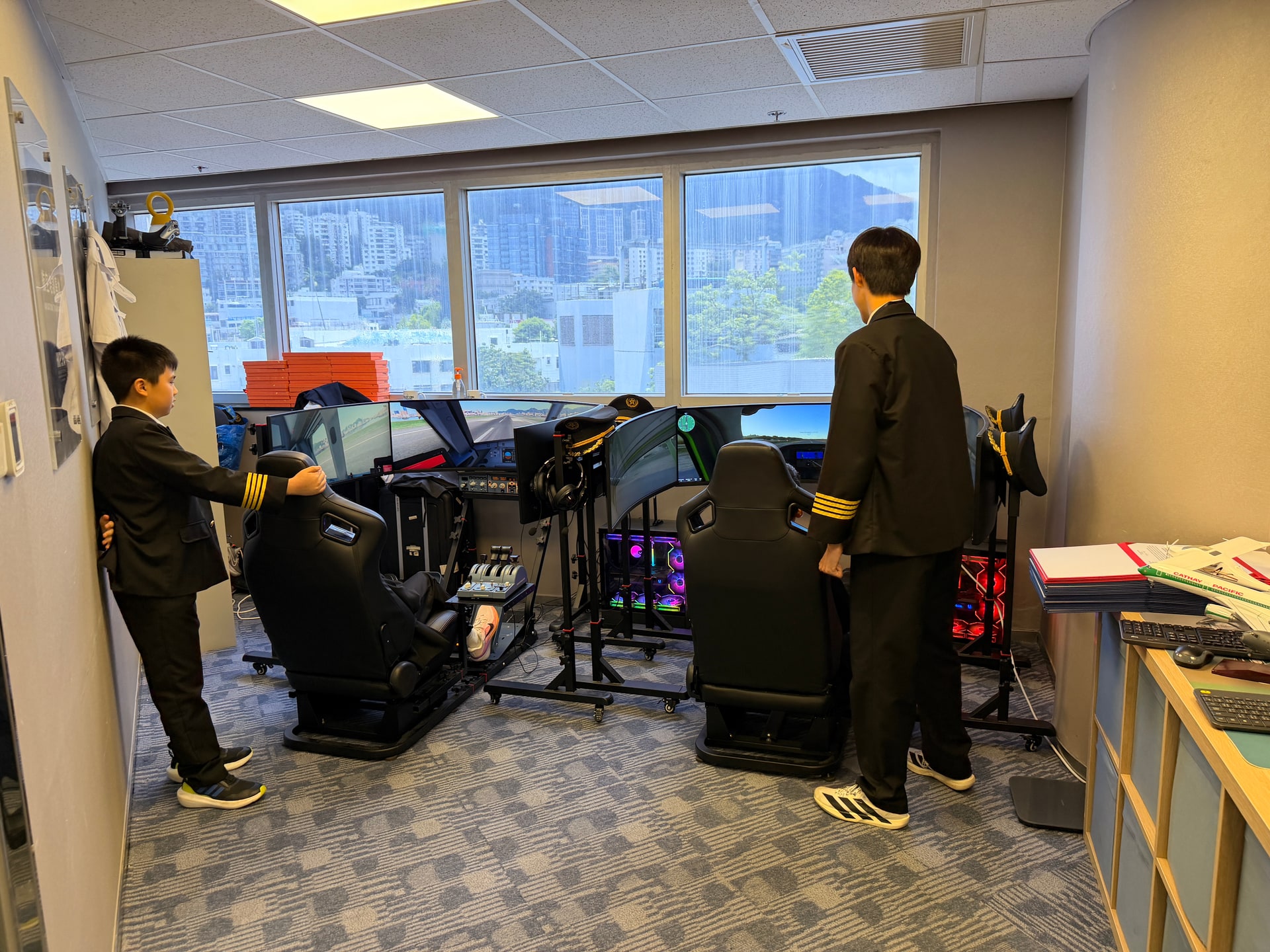 Two young participants explore HKPAPA flight simulators during Summer TechEd Fest 2026.