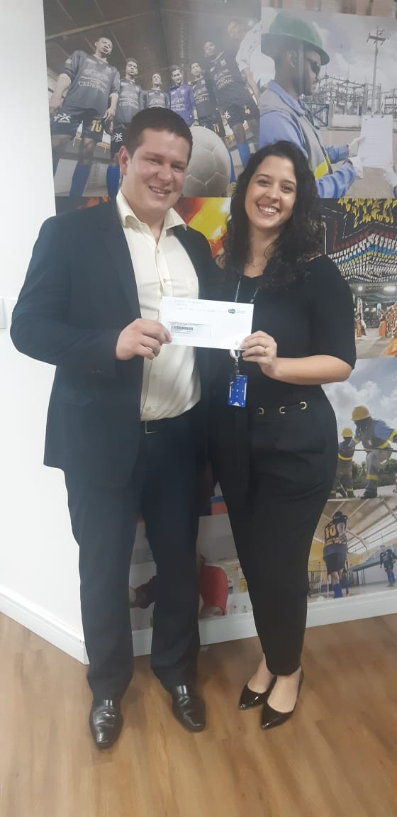Jacelena Dourado da Comunicação e Marketing da Equatorial Energia MA entregando um prêmio da Promoção Energia em Dia do ano passado. Pague em dia, faça o cadastro e concorra para 2020.