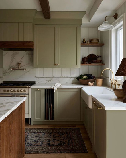 Green kitchen cabinets with off white range that give modern cottage vibes