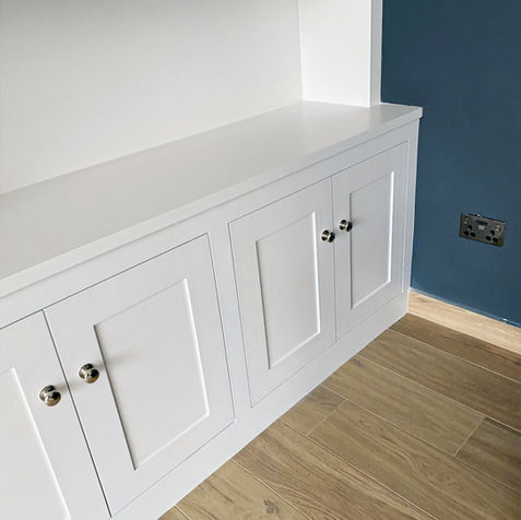 Detail shot of full-height in-frame cabinetry with white shaker-style doors, chrome hardware, and a flawless spray finish