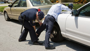 Police Pat Down. Uniformed police officer patting down a suspect pulled over during a traffic stop