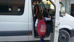 A girl with a backpack alighting on a minibus