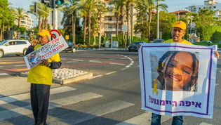 Two protesters, one holding a sign with a picture of Haymanot Kassau reading "Where is Haymanot"