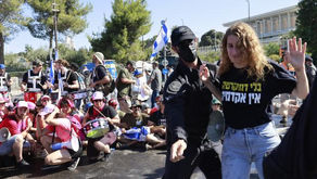 A police officer leading a woman away during a protest