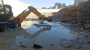 Open sewage with a construction vehicle in it