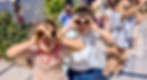 Children using cardboard tubes as binoculars during hands-on science activity at school