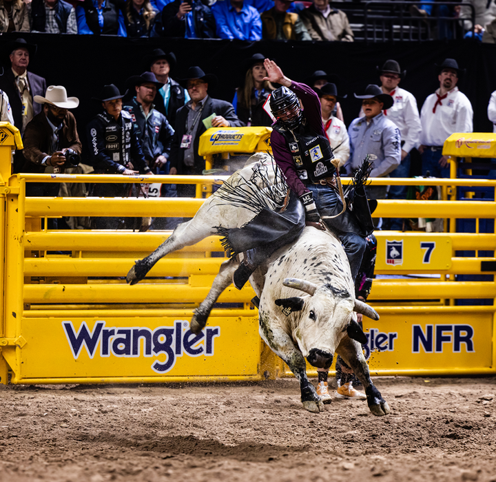 A bull rider clings to a bucking bull during a Wrangler NFR event.