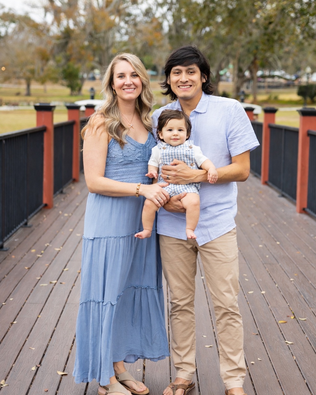 The family behind Cascade Shelter, a couple holding their baby on a wooden boardwalk