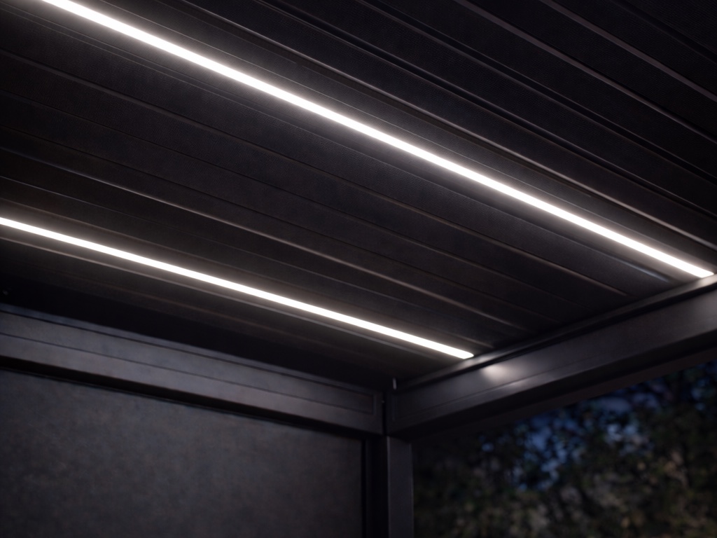 Soft white LED strips glowing in the louvers of a pergola roof at night