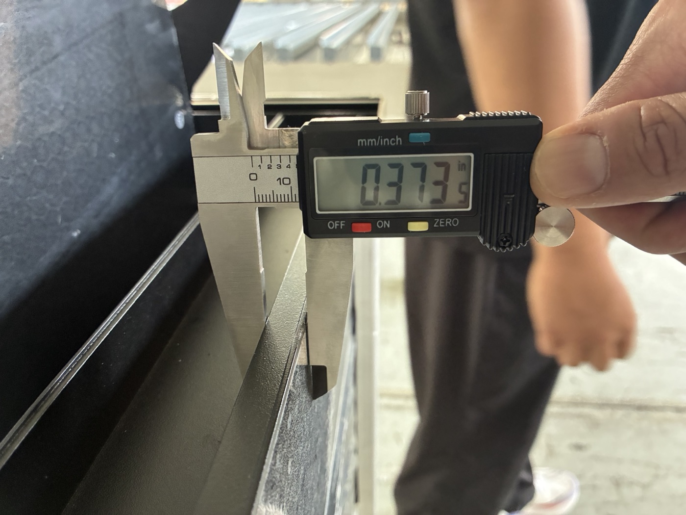 A digital caliper measuring the wall of an aluminum profile