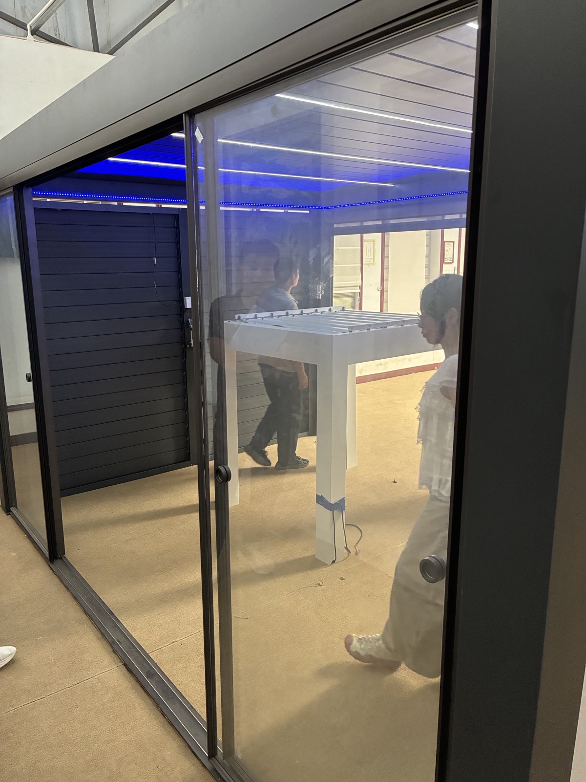 A pergola with a sliding glass enclosure in the factory showroom