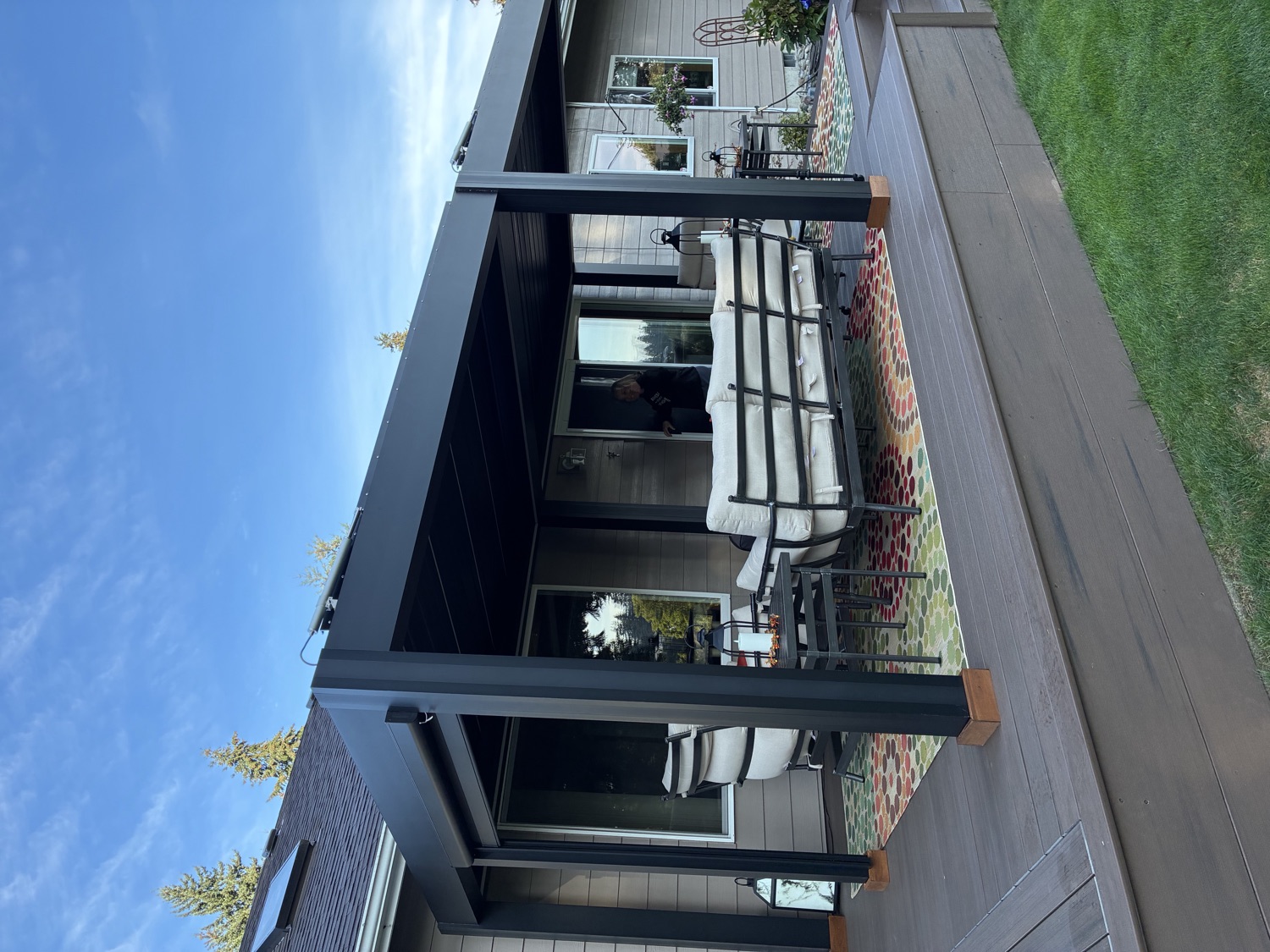 Corner view of the Puyallup pergola from the lawn, looking under the roof toward the house