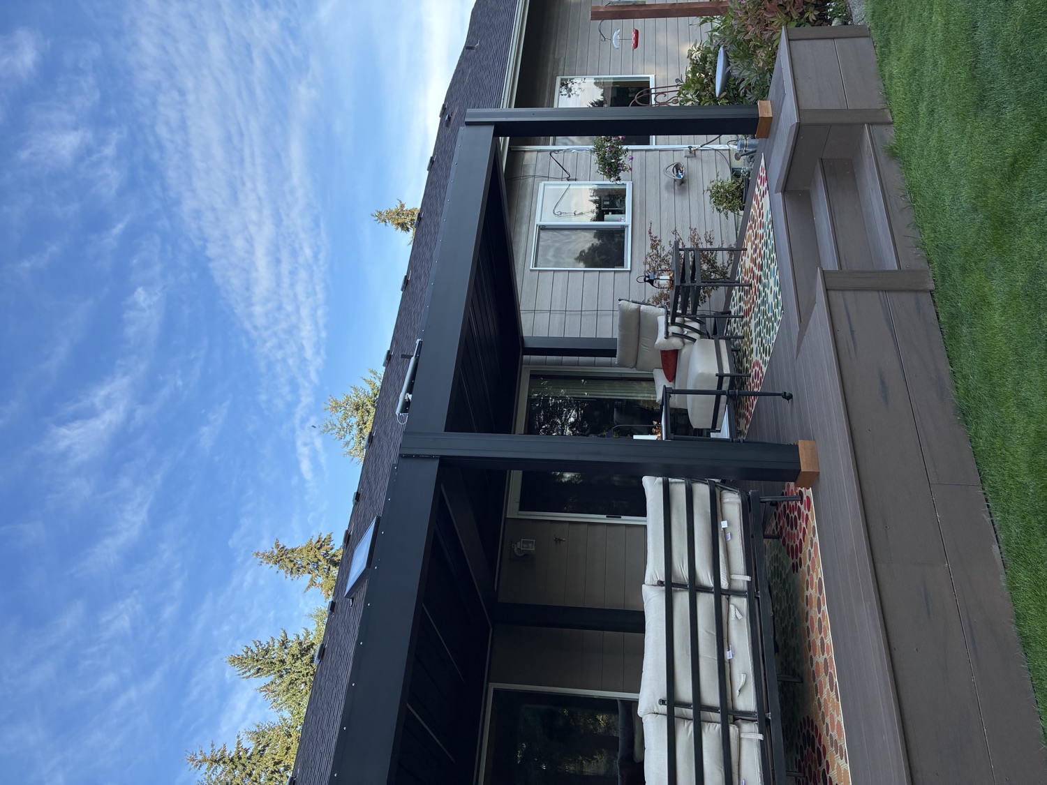 Side view of the Puyallup pergola showing the posts, deck steps and outdoor sofa underneath