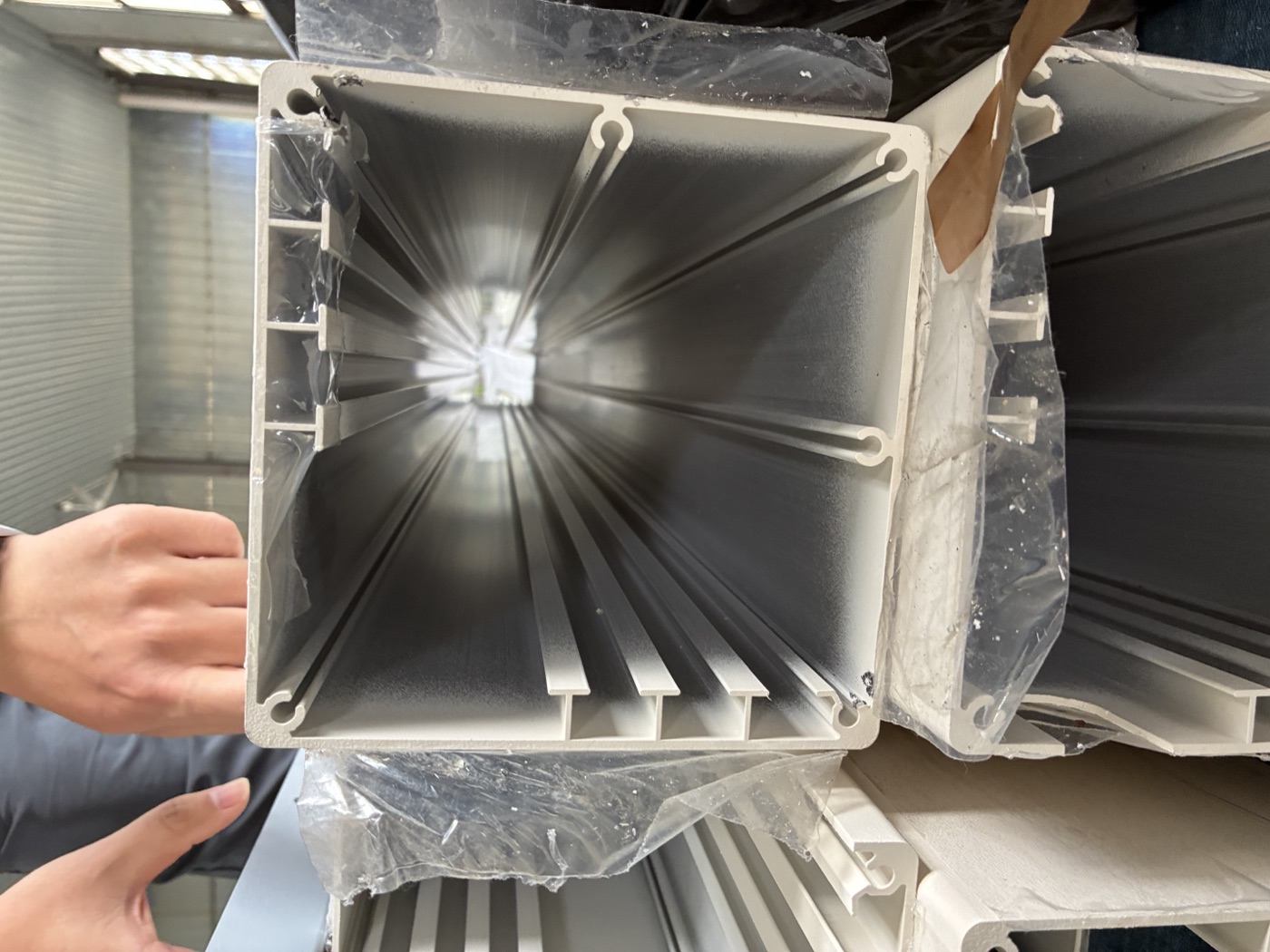 Looking down the inside of an aluminum post, showing the ribs along its inner walls