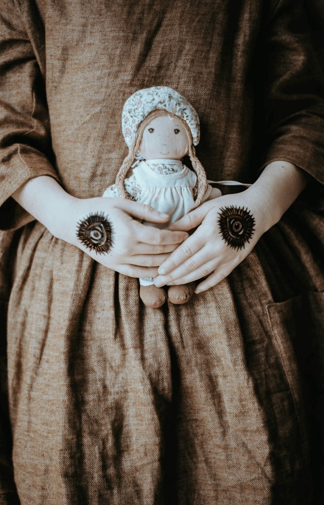 Person holding a voodoo doll during a binding ritual in New York City