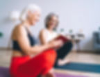 Firefly_Two people sitting on yoga mats, smiling, and sharing a book together of different