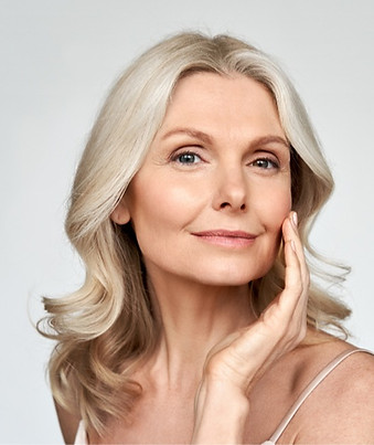Middle-aged woman with radiant, healthy skin, smiling confidently—showcasing the benefits of expert skincare and rejuvenation
