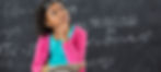 Young girl sits in front of a chalkboard with algebra problems written in chalk. She sits with a notebook in her lap and hand on chin in a thinking pose.