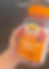 Hand holding orange supplement Gummies bottle.