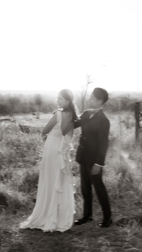 Black and white motion blur moment of honeymoon couple in wedding attire mid-twirl