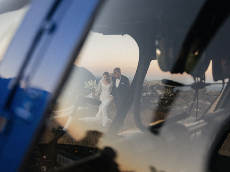 Bride and groom walking hand in hand reflected through helicopter window during South Africa elopement