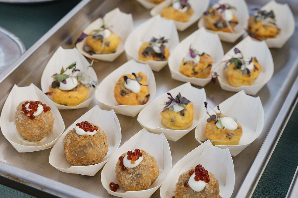 Small appetizers on a tray, featuring bite-sized balls with toppings and garnish.
