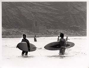 Two people walking out of the surf archive image of Lahinch beach.jpeg