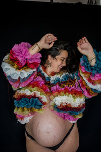 Portrait d'une femme souriante pendant une séance photo, exprimant confiance et sérénité.