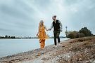 Hand in Hand laufen das Paar am Rhein von Düsseldorf. Verliebt schauen sie sich an, fotografiert von Mason Photography, Hochzeitsfotograf aus Düsseldorf.