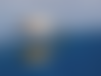 A gull with speckled plumage stands on ice by a blue lake, holding a fish in its beak. Its reflection is visible in the water.