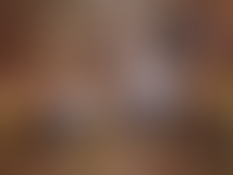 Three Canada geese fly over a calm pond, surrounded by autumnal trees and grass, showcasing brown and grey colors, creating a serene mood.