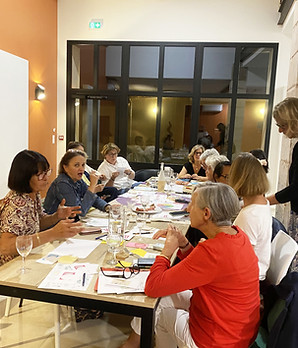 Réunion d'un groupe, plusieurs personnes autour d'une table, discussions animées.