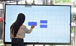 Mujer señalando una pantalla grande con un diagrama, en un contexto de Pizarra Digital en Guatemala.