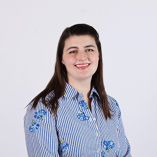 A headshot of Marie Culpepper wearing a striped blue shirt and smiling.
