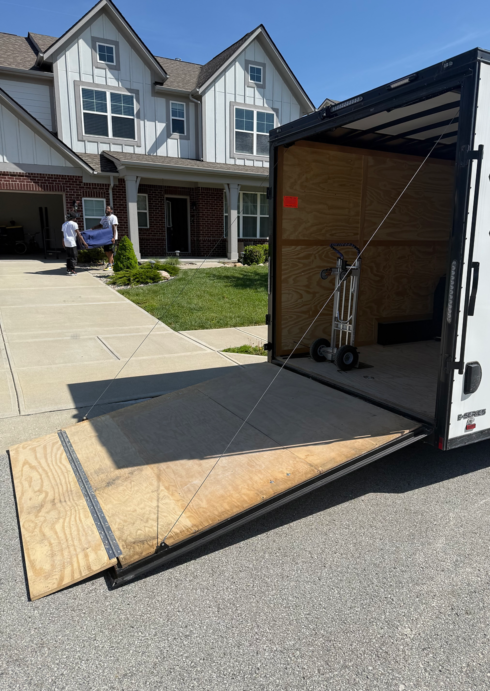 Movers carrying furniture piece into home.